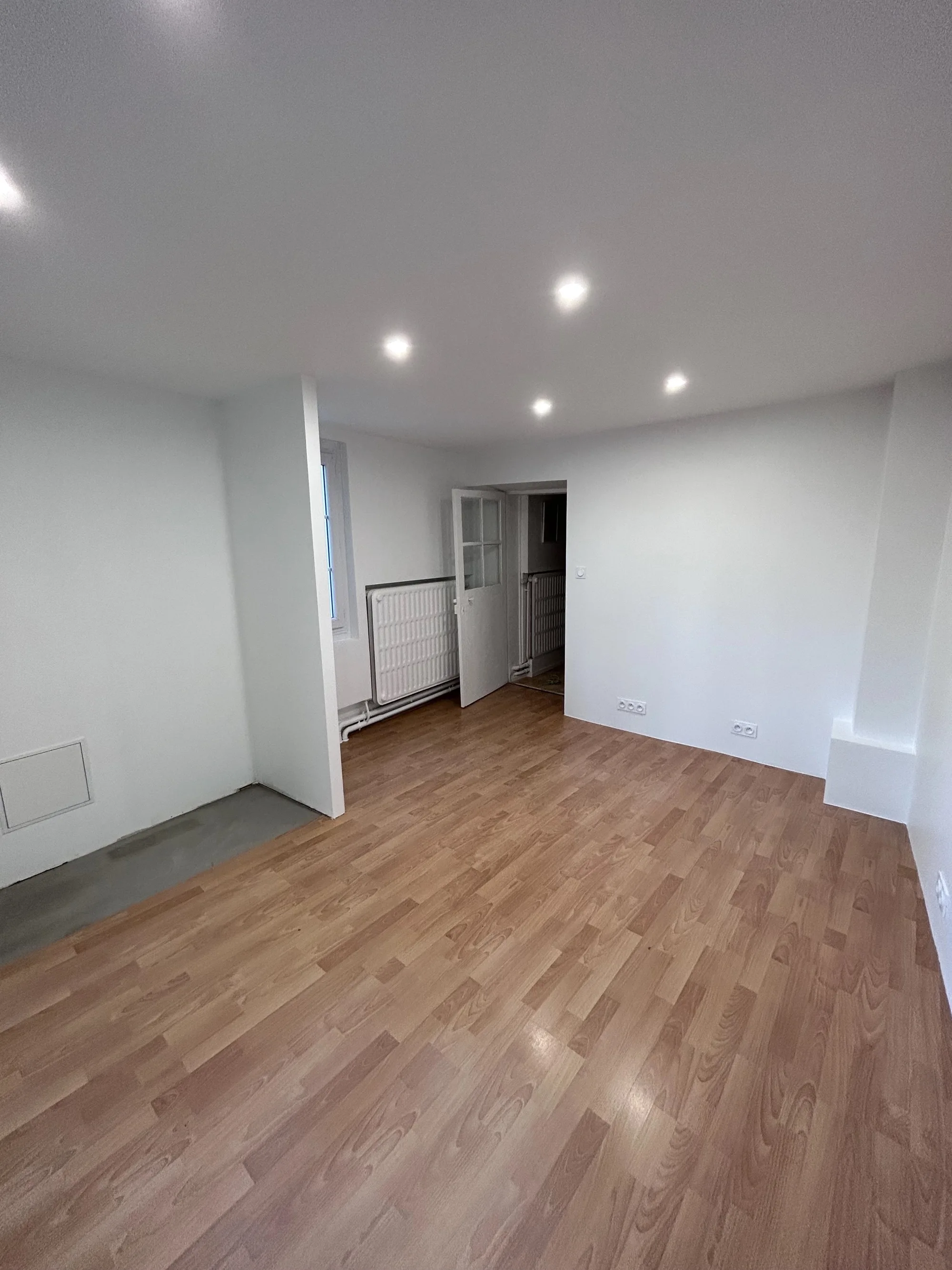 Le même séjour terminé : parquet posé, murs peints, spots encastrés